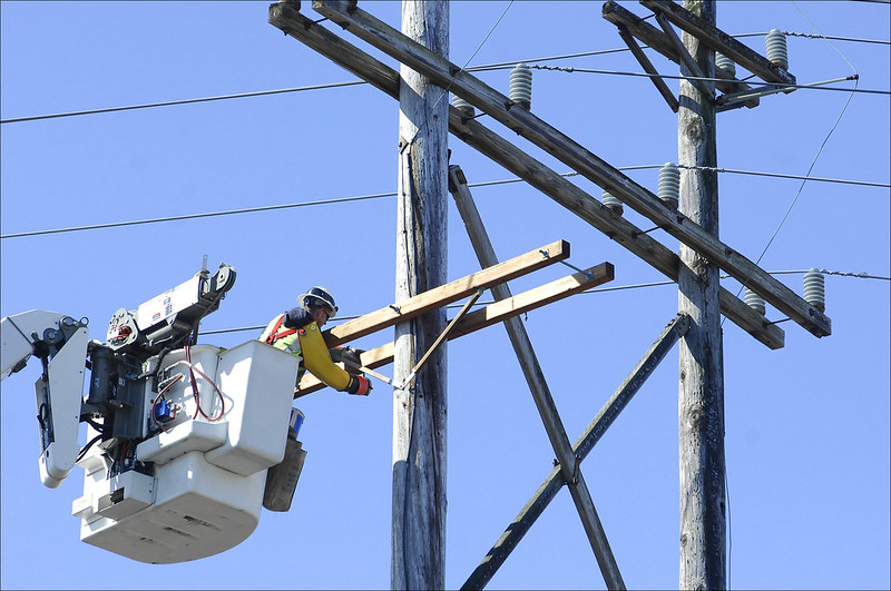 A lineman services a utility pole.