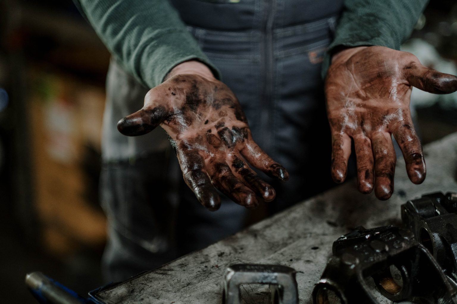 Closeup of a person's hands covered in motor oil